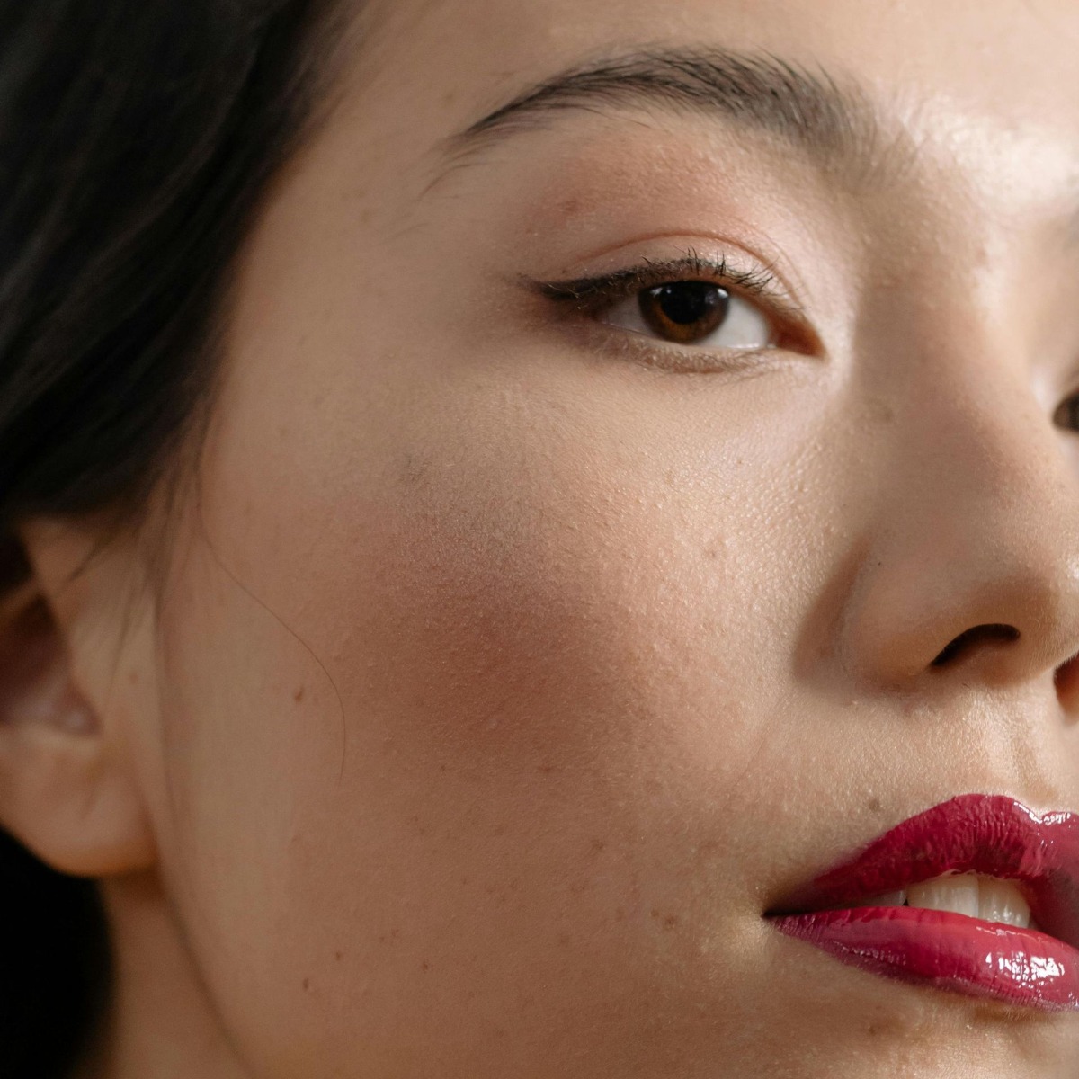 A woman confidently smiling, showcasing smooth, hair-free sideburns after permanent sideburns hair removal at Nios Spa in NYC